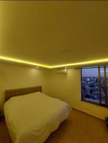 安曼The view IV的卧室配有白色的床和窗户。