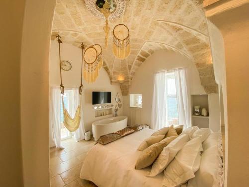 萨维勒特里Apulia Charming Suites - Casa Rossa Suite Perla e Suite Corallo的卧室配有一张大白色的床和沙发