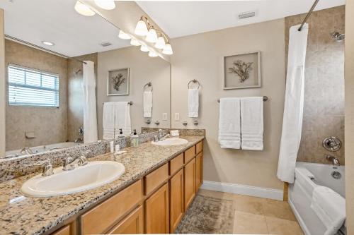 圣徒皮特海滩Palms of Treasure Island 405的一间带两个盥洗盆和大镜子的浴室