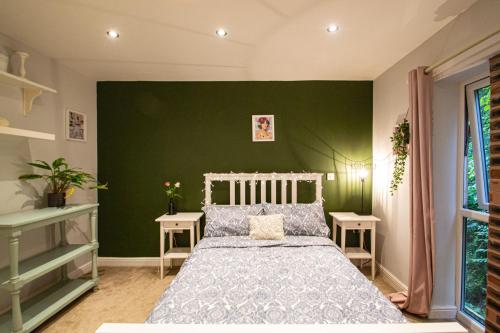 Tranquillity Suites Warrington 1bed Wifi Sleeps 4的一间卧室设有一张床和绿色的墙壁