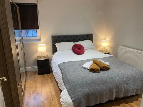 伦敦2 Bedroom Apartment Chiswick Park Tube Station的一间卧室配有一张带两个红色枕头的床