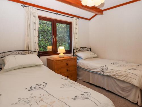 埃克塞特Dartmoor Retreat Lodge的带窗户的客房内的两张床