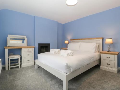 沃明斯特Granary Cottage的蓝色卧室,配有带2条毛巾的床