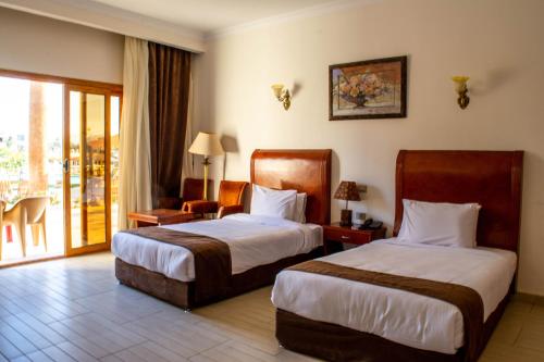 沙姆沙伊赫Palma Di Sharm Hollywood Resort的酒店客房设有两张床和一个阳台。