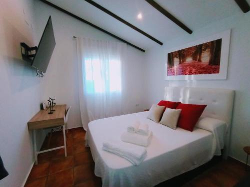 GójarCasa de Campo Los Manueles Ideal Perros Pet Friendly的卧室配有带红色枕头的白色床