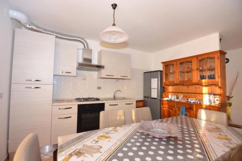 MontemitroShort-lets affittacamere的一间带桌子的厨房和一间带白色橱柜的厨房