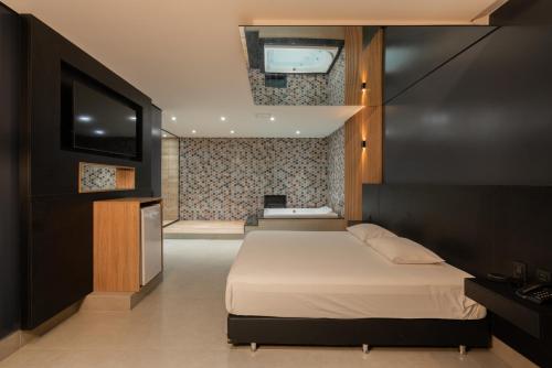 AraricaDrops Vale dos Sinos的一间卧室配有一张床和一台平面电视