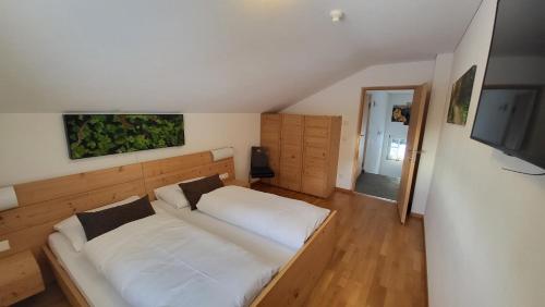 加伊斯Badl im Mühlbacher Talile的卧室配有一张白色大床和一台平面电视。