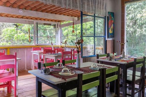 布鲁马迪纽Pousada das Brumas的用餐室设有桌椅和窗户。
