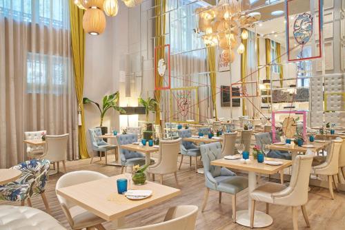 马德里NH系列马德里阿瓦斯卡尔酒店的餐厅设有桌椅和窗户。