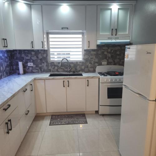 BarcelonetaParadise Escape的厨房配有白色橱柜、水槽和冰箱。