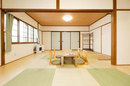 洞爷湖Guest House Matsuyoshi的配有桌椅的大房间