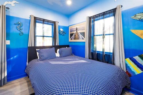 开普查尔斯Whimsical Tiny House, Cape Charles Virginia的蓝色的卧室设有蓝色的墙壁和窗户。