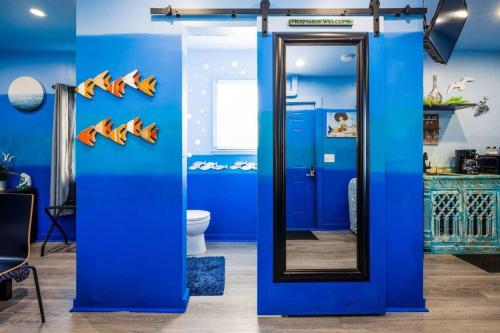 开普查尔斯Whimsical Tiny House, Cape Charles Virginia的蓝色的浴室设有镜子和卫生间