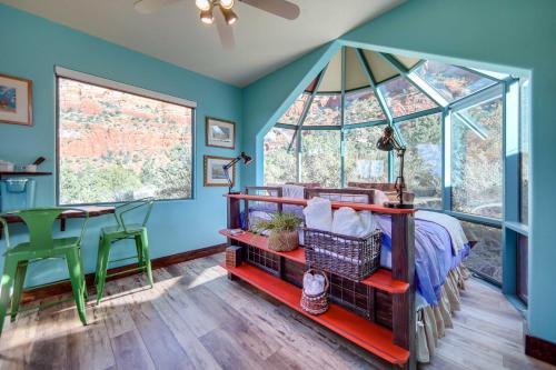塞多纳Sedona Studio with Amazing View and On-Site Hiking!的一间拥有蓝色墙壁的卧室,配有一张床和一张桌子