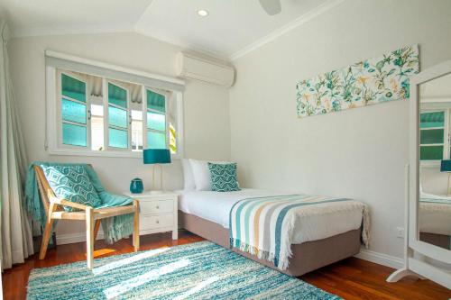 艾吉希尔Malawi House的一间卧室配有一张床、一把椅子和窗户。