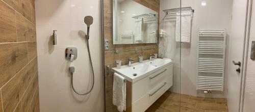 弗林布尔克Wellness & Spa Apartments Lipno - Frymburk的白色的浴室设有水槽和淋浴。