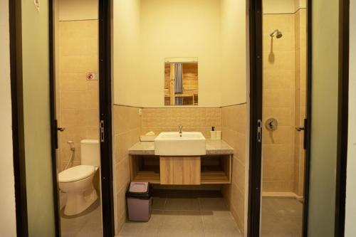 塞米亚克K Hostel Seminyak的一间带水槽、卫生间和镜子的浴室