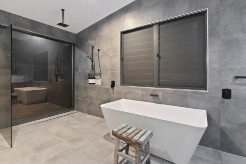 凯恩斯Villa Thirty One - Balinese inspired Escape的一间带大型白色浴缸和淋浴的浴室