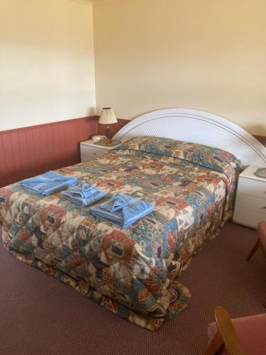 Maclagan蓝杰穆尔旅馆的酒店客房的床铺上配有蓝色毛巾