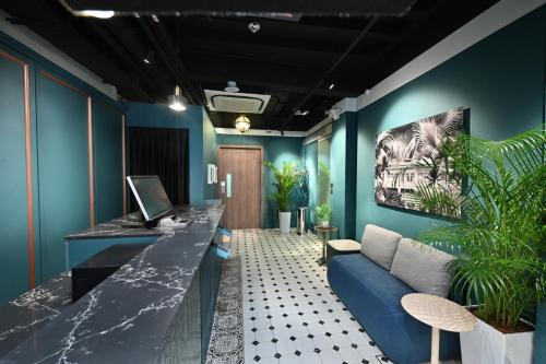 新加坡Dream Chaser Boutique Capsule Hotel的客厅拥有蓝色的墙壁和蓝色的沙发
