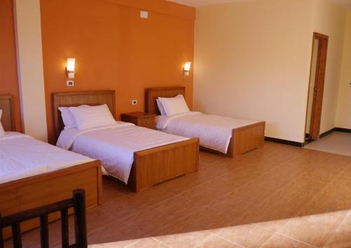 拉利贝拉Bete Serkie Lalibela的酒店客房,配有两张带白色床单的床