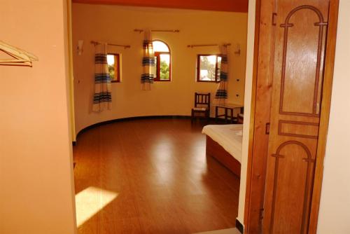 拉利贝拉Bete Serkie Lalibela的客房设有一张床,铺有木地板。