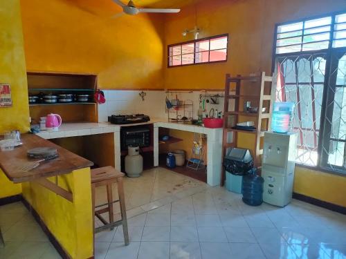 帝力Casa Minha Backpackers Hostel的厨房设有黄色的墙壁和台面