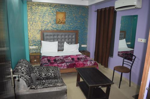 戈勒克布尔HOTEL SAI PALACE的卧室配有1张床、1张桌子和1把椅子
