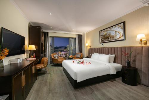 河内San Palace Hotel & Spa的酒店客房设有一张大床和一间客厅。