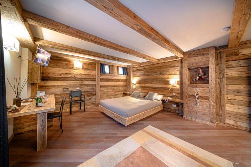 阿帕里卡Hotel Ambrosini的一间卧室设有木墙、一张床和一张书桌