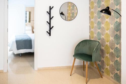 贝尼多姆CALMA Apartments的配有绿色椅子和镜子的客房