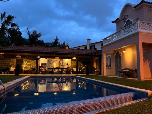 丰沙尔Casa do Poço Funchal的房屋前有游泳池的房子