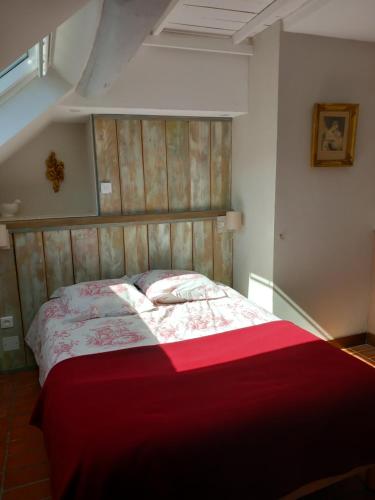 Châtresle Portail bleu的一间卧室配有一张带红色毯子的大床