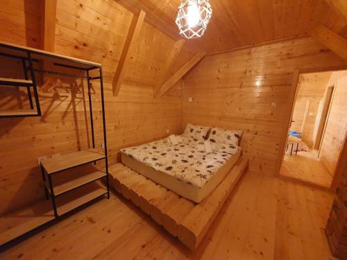 科拉欣Anna's Mountain House的木制客房内的一间卧室,配有一张床