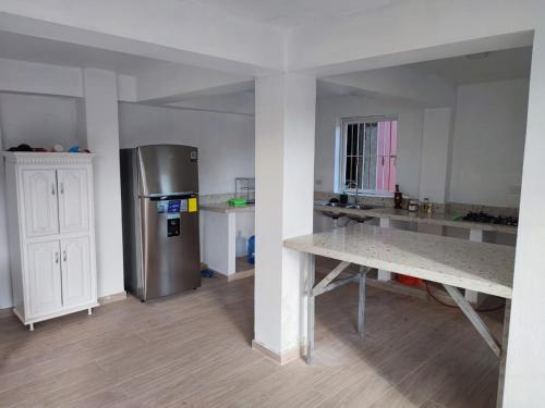 圣塔芭芭拉-山美纳Samana house的厨房配有不锈钢冰箱和桌子