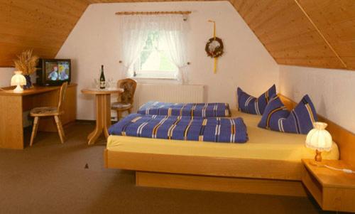 DorfchemnitzGaststätte & Pension Alte Mühle的一间卧室配有一张带蓝色枕头的床和一扇窗户。