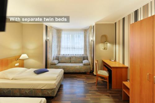 美因河畔法兰克福戴安娜菲儿别墅酒店的配有一张床和一张书桌的酒店客房