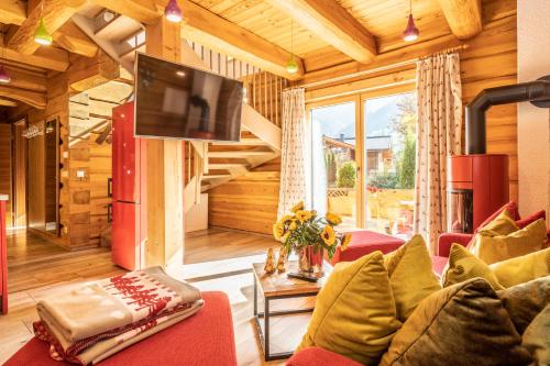 卡普伦The Kaprun Edition - Luxury Chalets & Style Suites的客厅配有红色沙发和电视