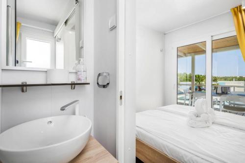 奥米沙利Mobile Homes in Camping Omisalj, island Krk, with swimmingpool的白色的浴室设有浴缸和水槽。