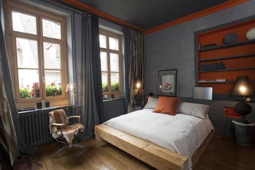 蓬塔利耶科特迪瓦庄园旅馆的一间卧室配有一张床、一把椅子和窗户。