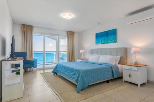 马霍礁Sunset Beach Condo - Luxury 1BR Suite next to The Morgan Resort的一间卧室配有一张床,享有海景