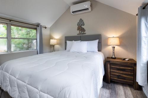 Lake PanasoffkeeIdlewild Lodge and RV Park的卧室设有一张白色大床和一扇窗户。