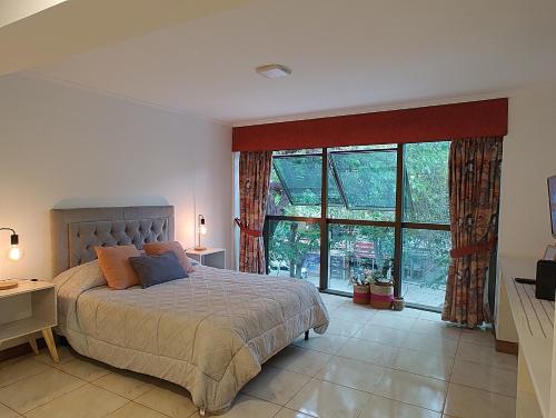 门多萨MENDOZA Suites 8的一间卧室设有一张床和一个大窗户
