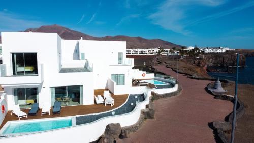 普拉亚布兰卡CalaLanzarote Suites Hotel - Adults Only的一座带游泳池的大型白色建筑