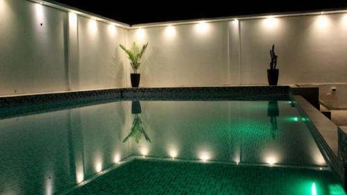 马尔多纳多港D´Milez Hotel的一座带灯光的游泳池