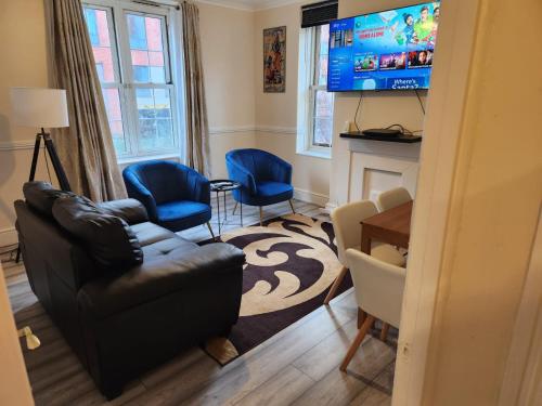 伦敦2-bedroom flat in Cutty-Sark, Greenwich !的客厅配有沙发、两把椅子和电视