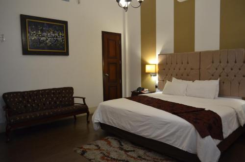 瓜亚基尔Hotel Patrimonial by Greenfield的一间卧室配有一张大床和一把椅子