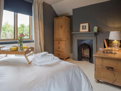 Stretton on FosseStation Lodge的卧室配有白色的床和壁炉