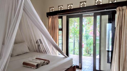 吉利阿尔萨里里别墅酒店的一间卧室配有一张带毛巾的天蓬床。